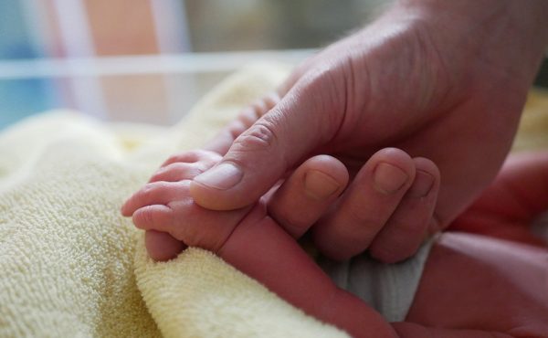 Vater hält Hand seiner neugeborenen Tochter – 1000. Geburt 2026